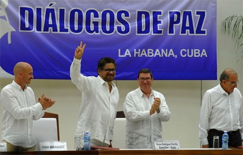 representante de las FARC en las negociaciones realiza el signo de la victoria